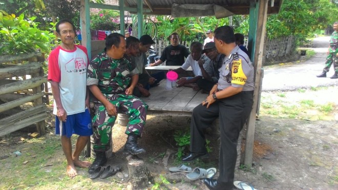 Terlihat Babinsa dan Babintibkamas membantu warga membangun poskamling.